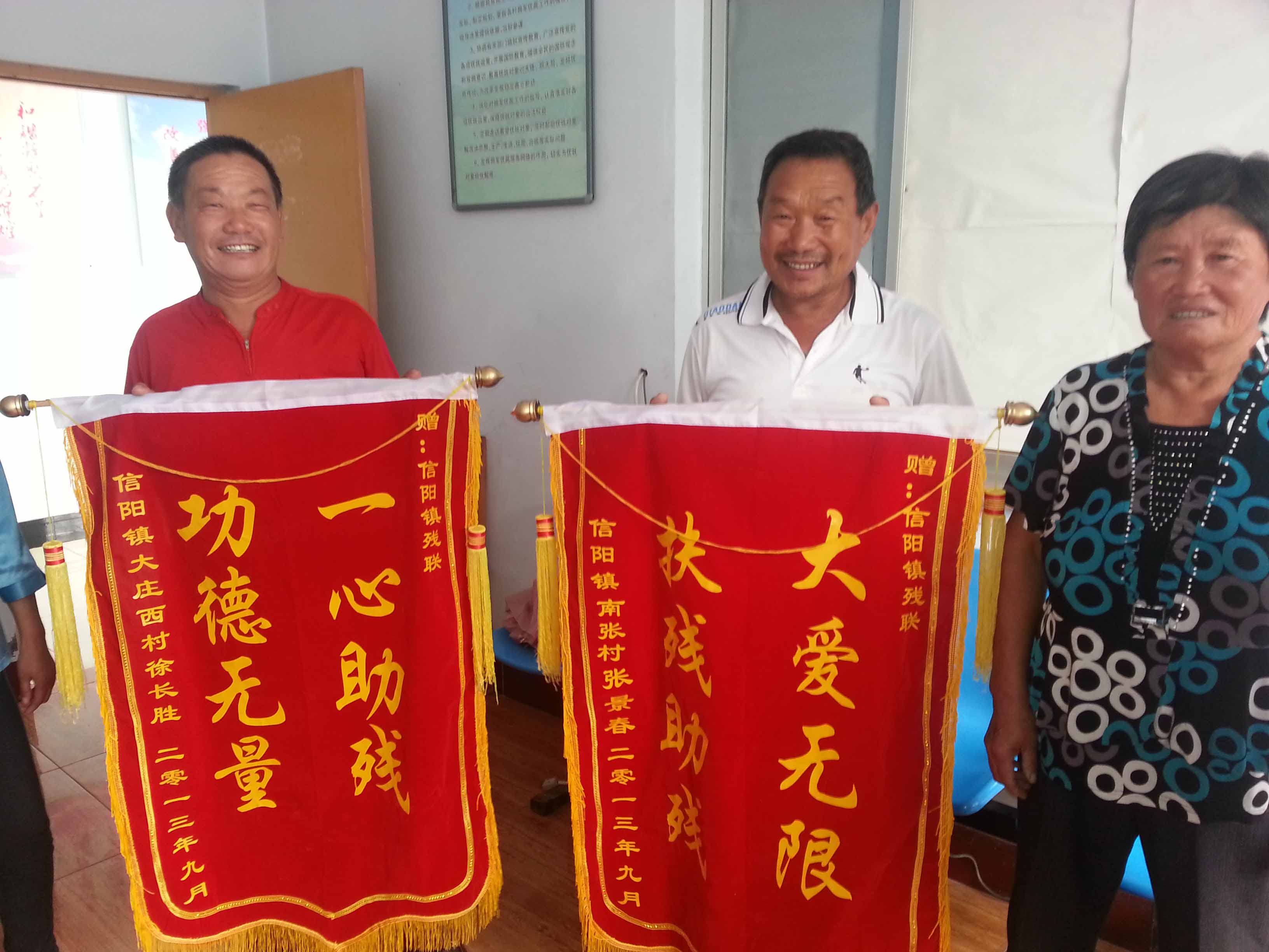 两位残疾人手持锦旗合影