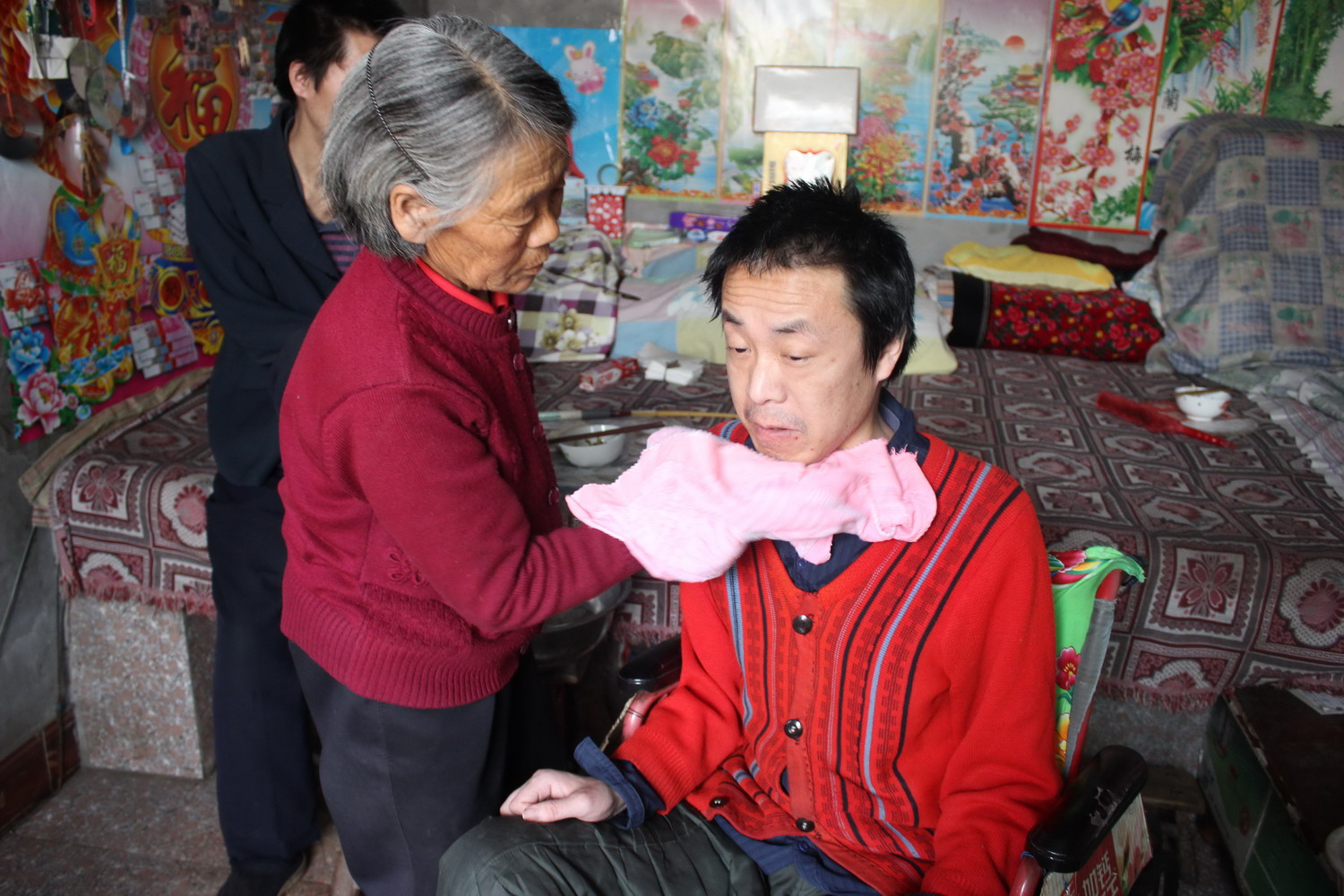 图为李忠玲用热毛巾给二儿子杜元泊擦脸